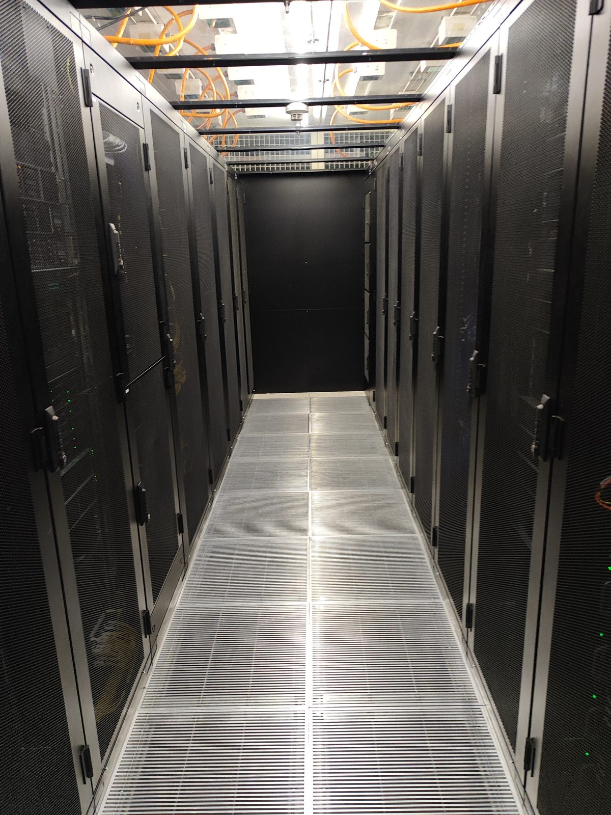 Rangées de baies dans le cold corridor de la salle colocation standard des salles privatives AlpineDC à Crissier
